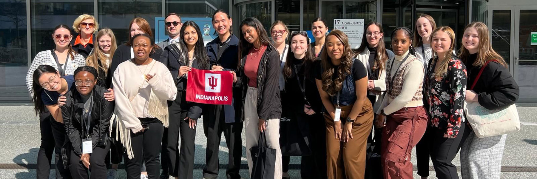 group of study abroad students holding iu indianapolis flag in geneva