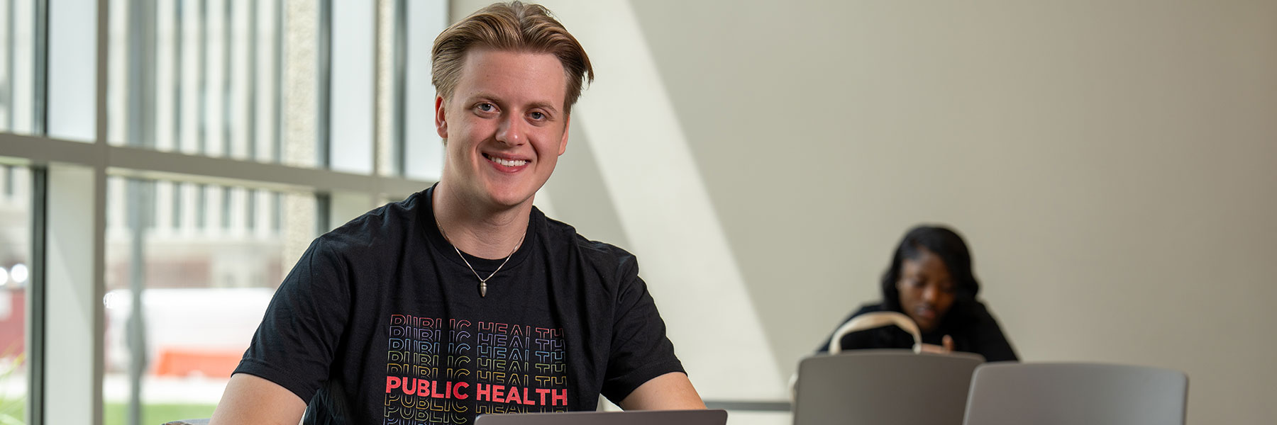 smiling public health student in the health sciences building