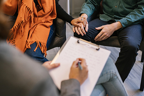 couple holding hands at physician's office
